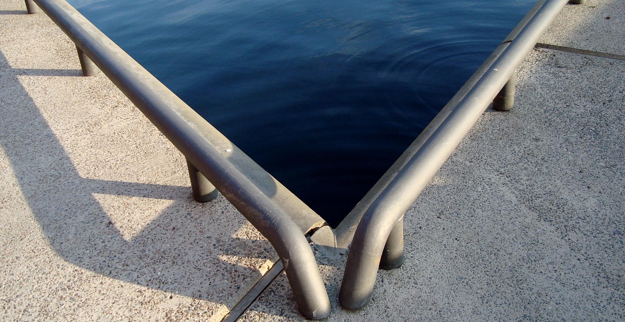 Metallgeländer an einer Wasserkante als Kontaktmotiv für den Standort Kiel.